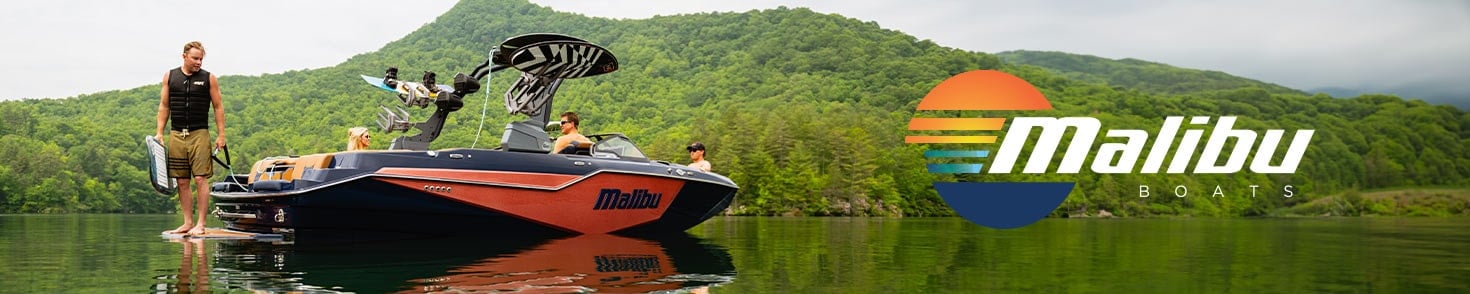 Malibu Boat with Wake surfer standing at back of boat